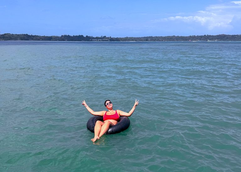 smiling woman tubing on blue sea water