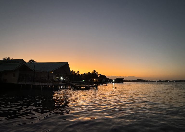 over-the-water bungalows on sea at sunset