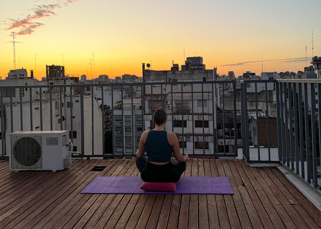 woman meditating on rooftop Buenos Aires sunset