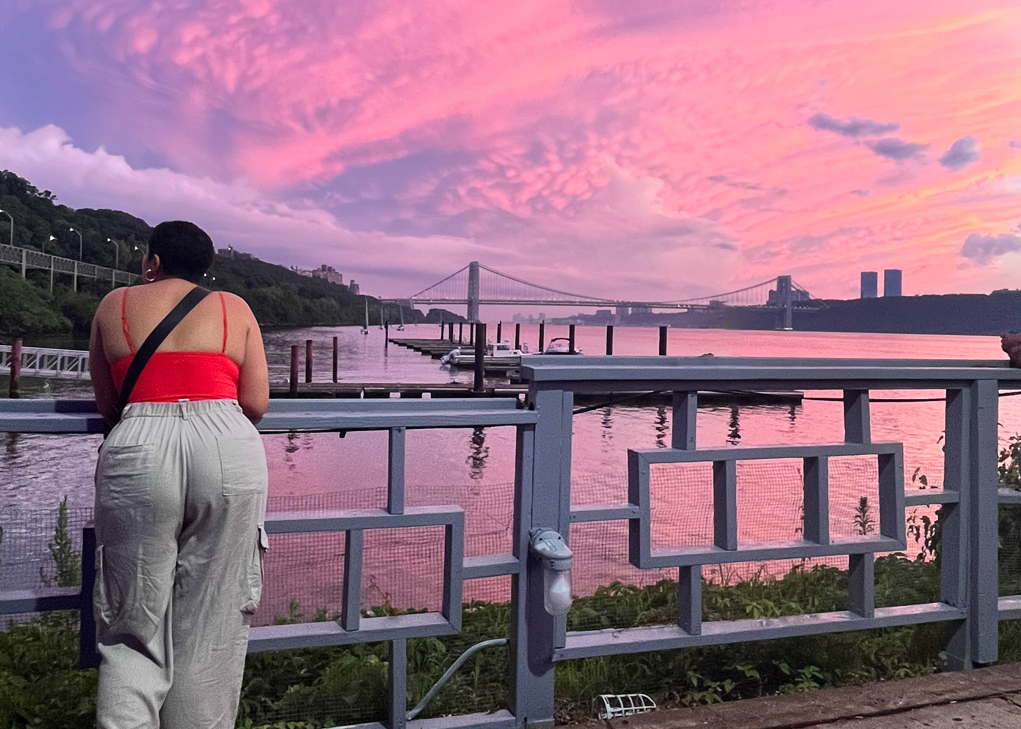 woman standing by pink sky and New York City background