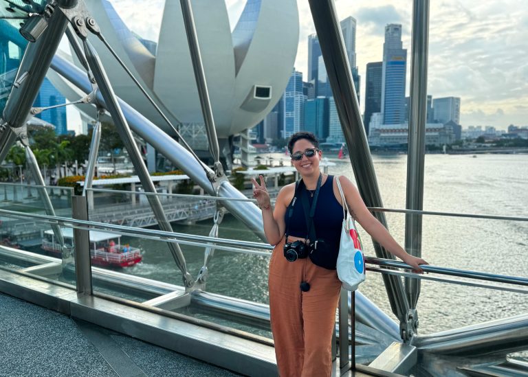 woman standing on Helix bridge Singapore city skyline view