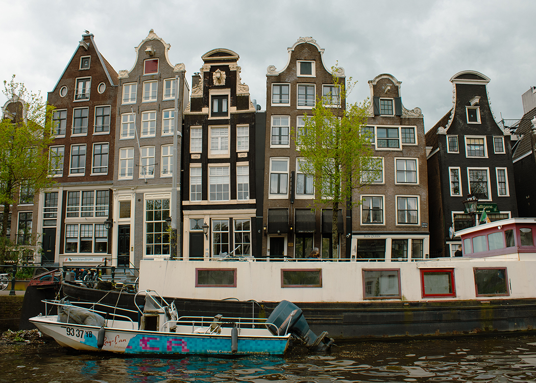 boat and crooked houses on Amsterdam canal