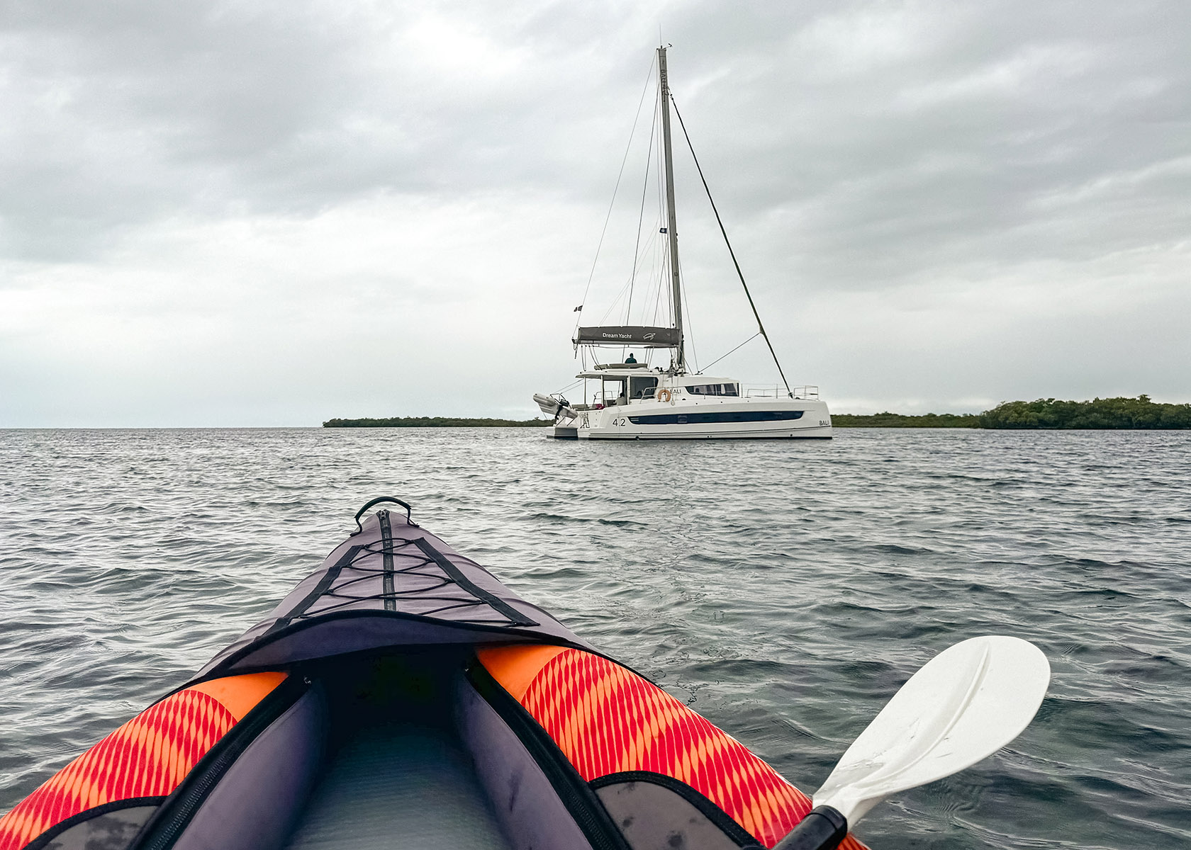 Orange kayak and paddle facing Bali 4.2 Catamaran Dream Yacht Charter boat